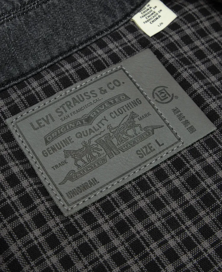 墨黑丹寧外套具有寬鬆剪裁、洋蔥圖案絎縫和法蘭絨格紋內襯細節。品牌提供