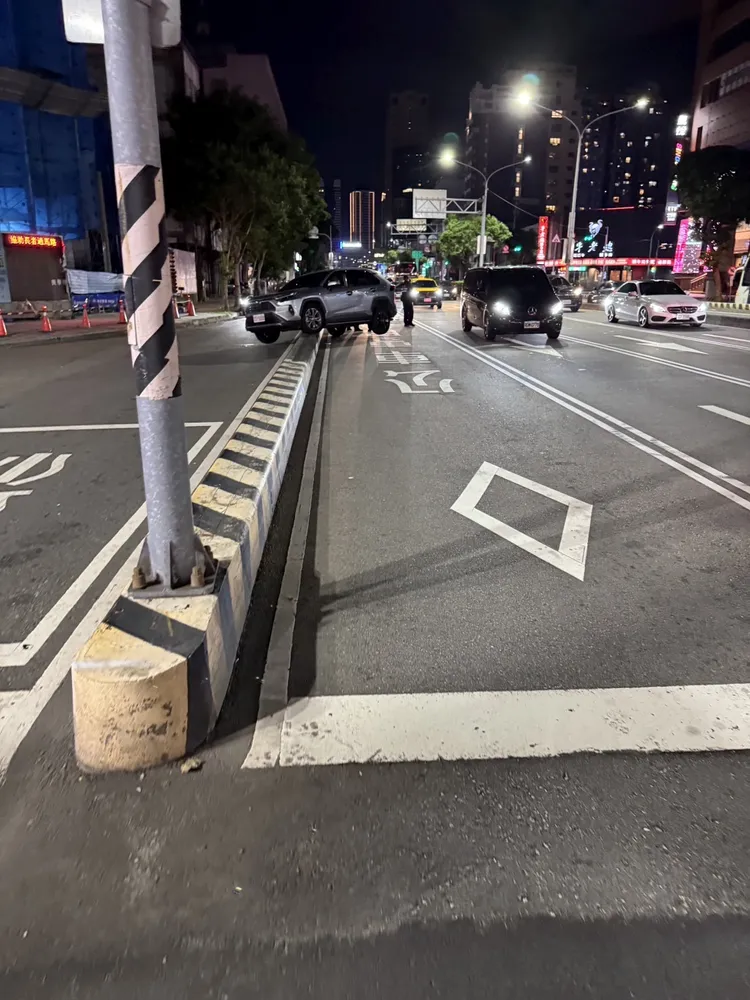 多元計程車疑違規開進公車專用道又想違規右轉，結果開上分隔島動彈不得。民眾提供