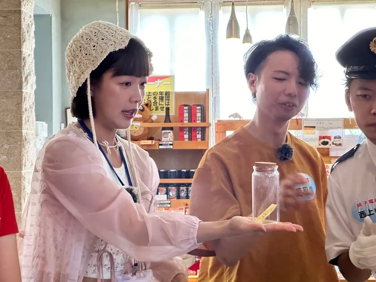 籃籃（左）發揮創意，提出可以用玻璃瓶裝空氣，再放上銚子車站的車票做宣傳。民視提供