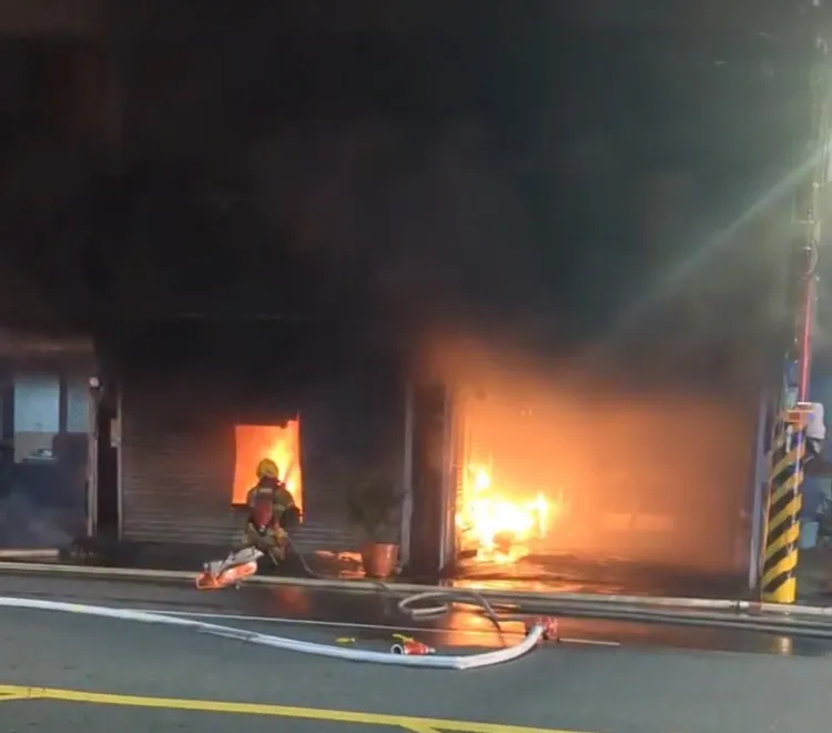 消防人員以機具破門射水灌救。民眾提供