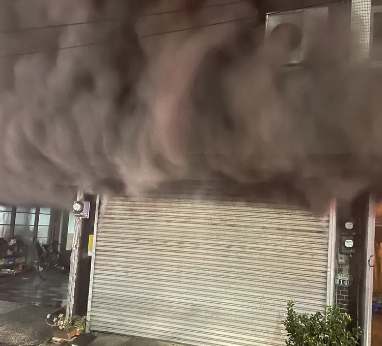 濃煙不斷從1樓鐵捲門縫隙竄出。民眾提供