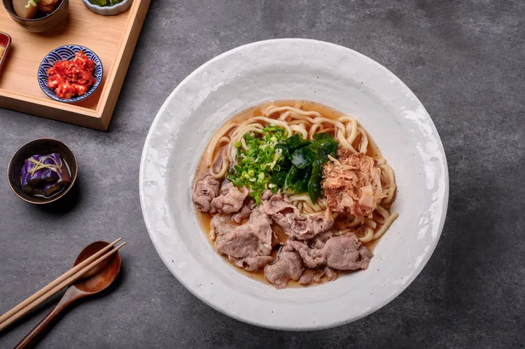 切麥狐狸 烏龍麵專賣針對2店中山店全新研發多款烏龍麵品項，包括味覺滿分香嫩滑口「牛肉烏龍麵」，採用軟嫩多汁美國牛培根，油花豐富，肉質鮮美，上桌前使用烏龍麵高湯輕涮，吸附湯頭食材鮮甜味。(大碗250元，小碗160元)。業者提供