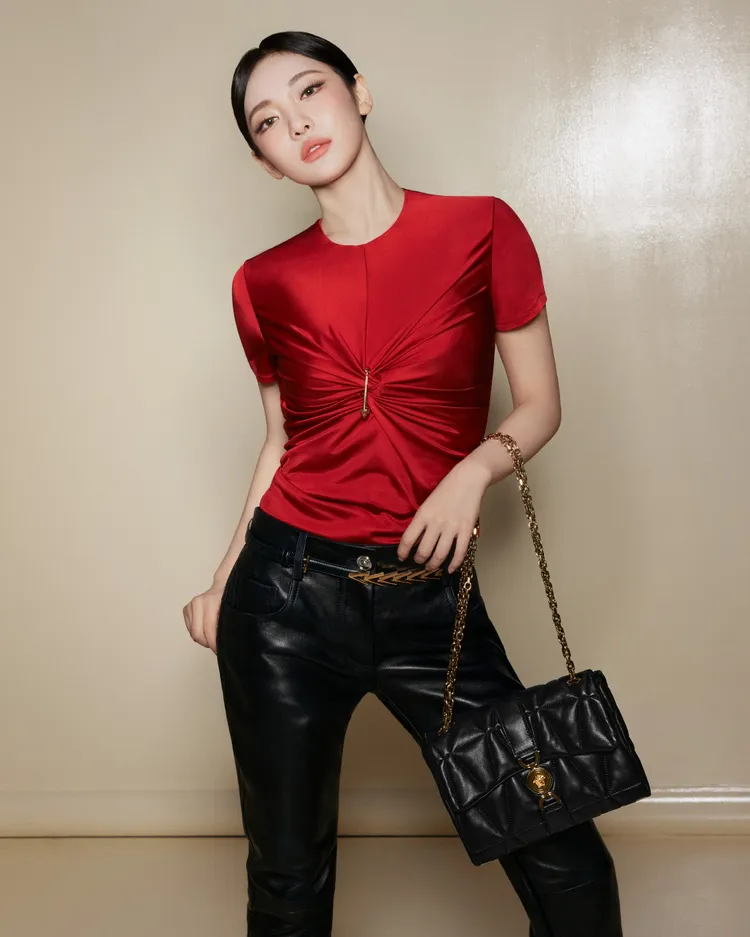 寧藝卓穿著扭結紅色緊身上衣、黑皮褲並搭配Kleio包。品牌提供