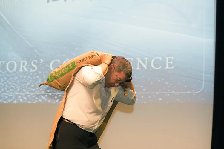 台泥今日舉辦法說會，台泥董事長張安平特別扛著40公斤的台泥卜特蘭石灰石水泥出場。台泥提供