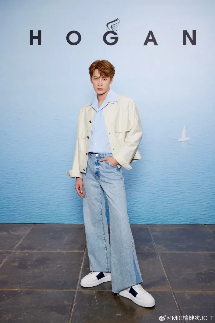 檀健次以米色短版外套搭上藍襯衫、拼接丹寧褲，並腳踩黑色皮標H-Stripes。品牌提供