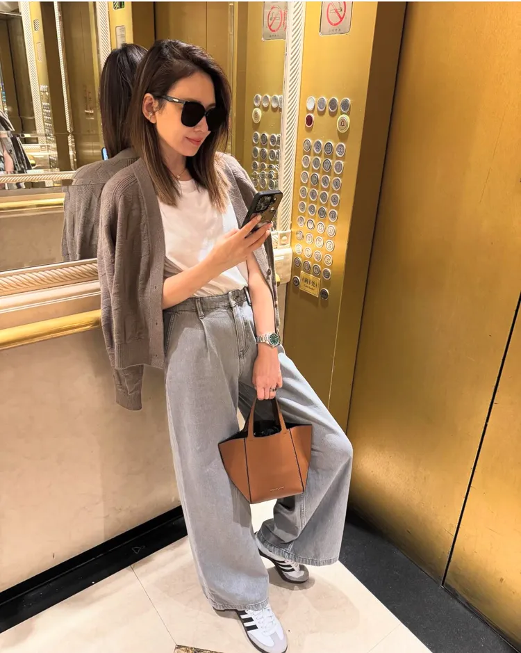 Melody手持MICHAEL KORS JORDI棕色小提包，1萬5000元。品牌提供