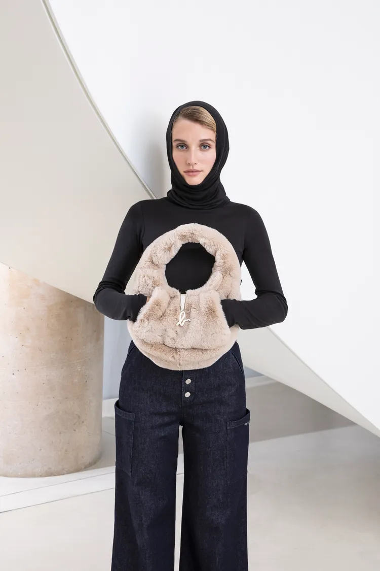 毛絨單肩包兩側內嵌口袋在嚴寒中可作為暖手用途。品牌提供