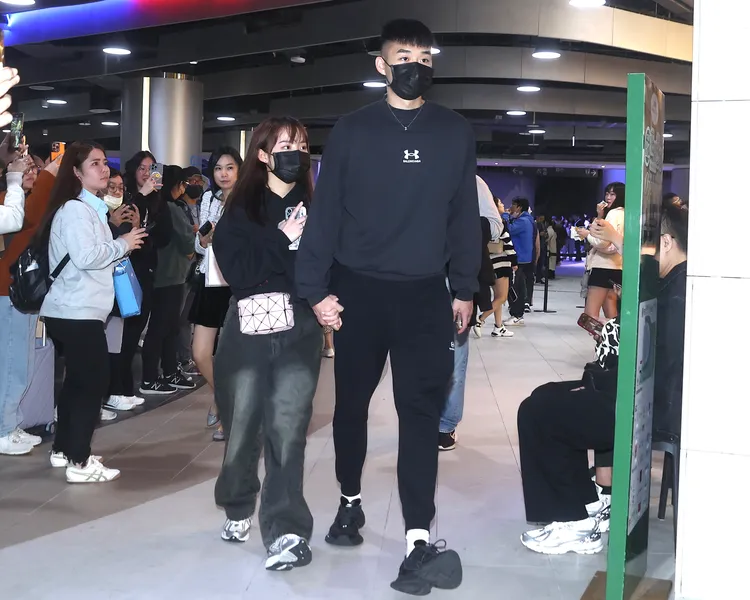 奧運羽球男雙金牌王齊麟（右）牽著未婚妻陳詩媛到大巨蛋欣賞周杰倫演唱會。特勤中心攝