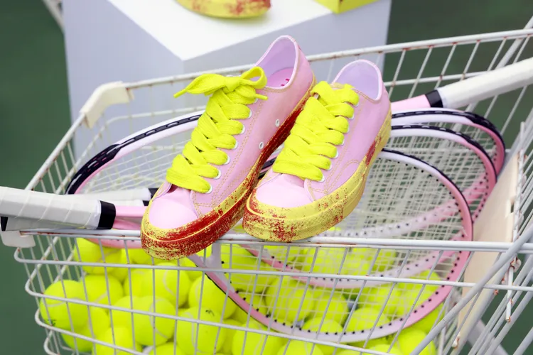 螢光色鞋底上的紅土色調呼應網球場地的紅土元素。品牌提供