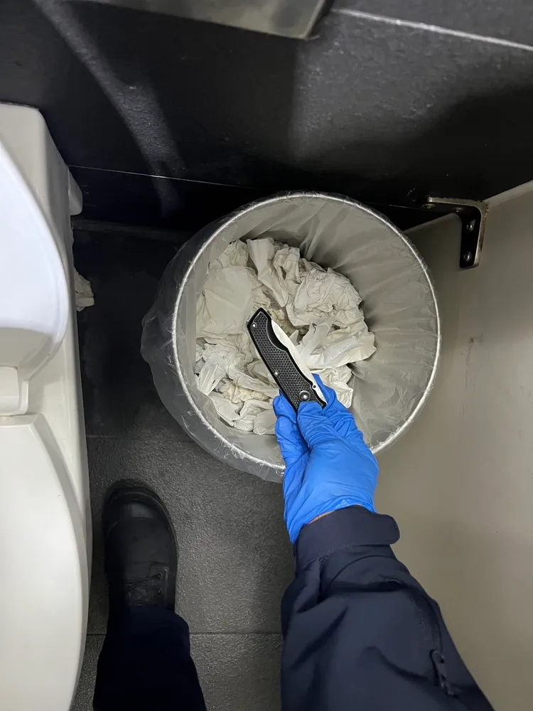 警方於男廁內垃圾桶查扣凶器折疊刀。翻攝畫面