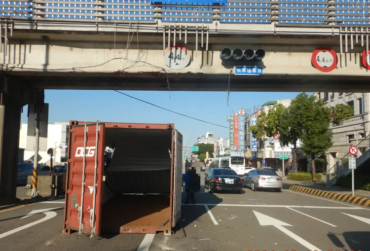 貨櫃車撞上陸橋，貨櫃落地，造成行人陸橋受損、號誌故障、路面坑洞。翻攝畫面