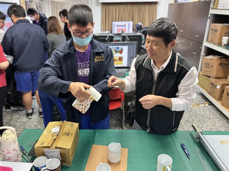南分署職訓師郭文軒(右)指導學員卸除馬克杯轉印圖案。分署提供