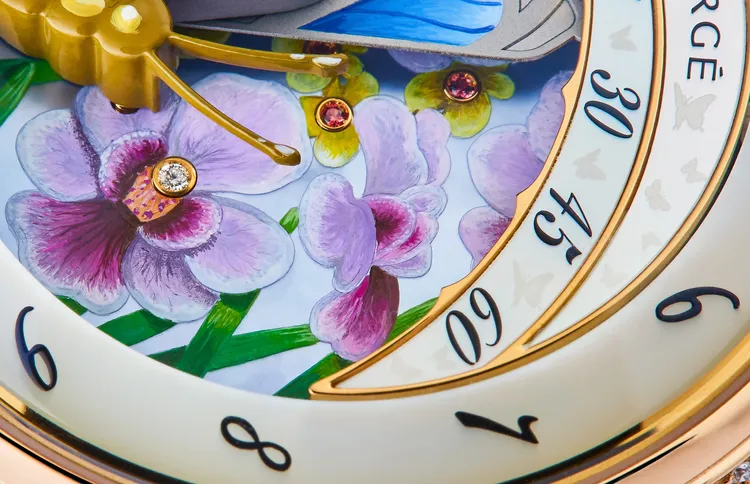 小時圈與分針圈由珍珠母貝手工製成，錶盤上飾有微繪花卉圖案與手工鑲嵌的粉紅藍寶石。品牌提供