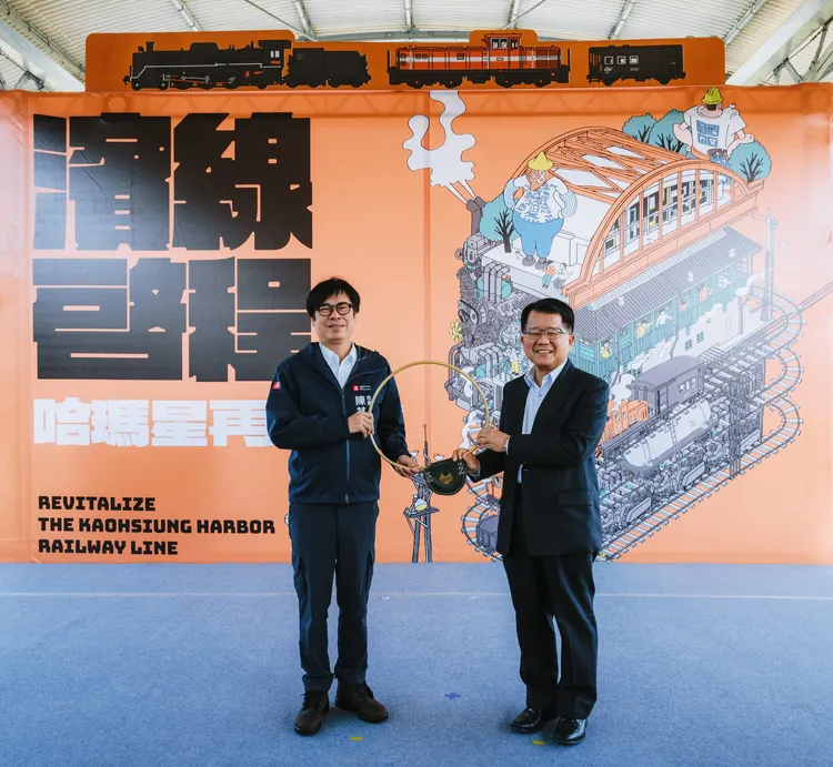 陳其邁市長從高雄港站前站長陳文川手上，接下象徵火車通行證的「電氣路牌」。市府提供