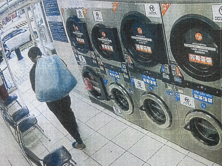 邱男竊得衣物步出自助洗衣店。翻攝畫面