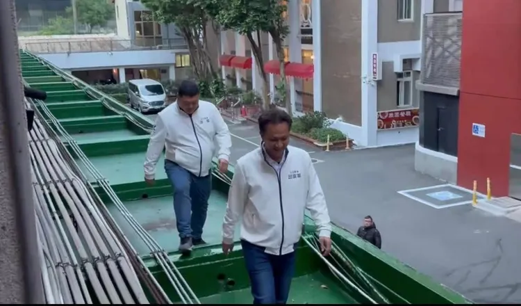 藍委爬牆行走在屋簷上。翻攝黃捷臉書