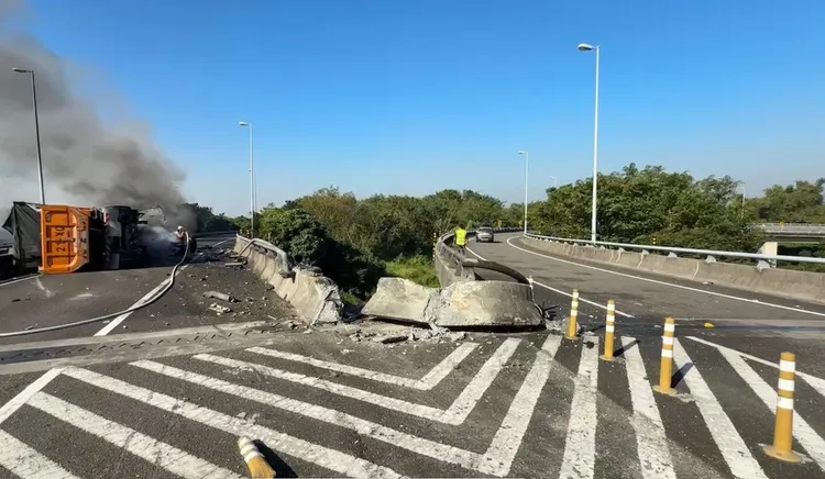 砂石車撞擊水泥護欄後側翻，隨即起火燃燒。讀者提供