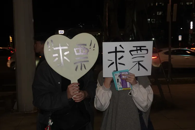 不願露臉的正妹在場外求票。江孟謙攝