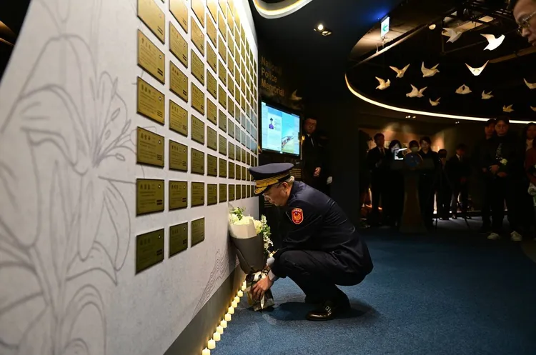 警政署署長張榮興率警察同仁默念並獻上象徵純潔與奉獻的白玫瑰花。警方提供