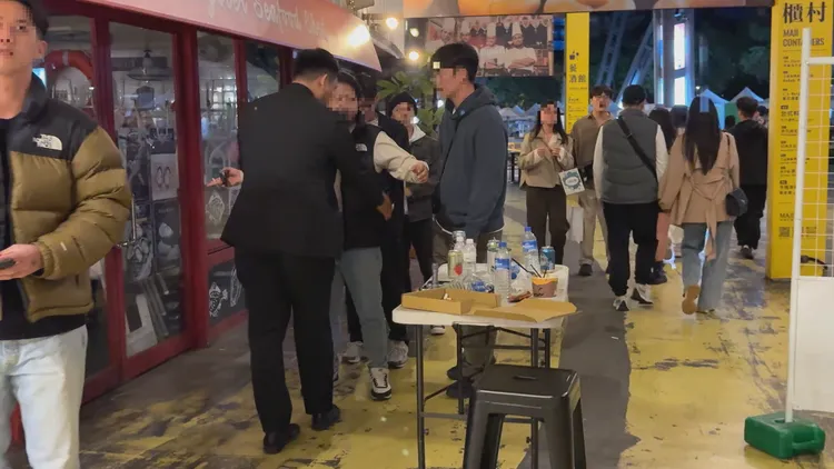 安管人員針對男性顧客進行搜身檢查。攝影中心