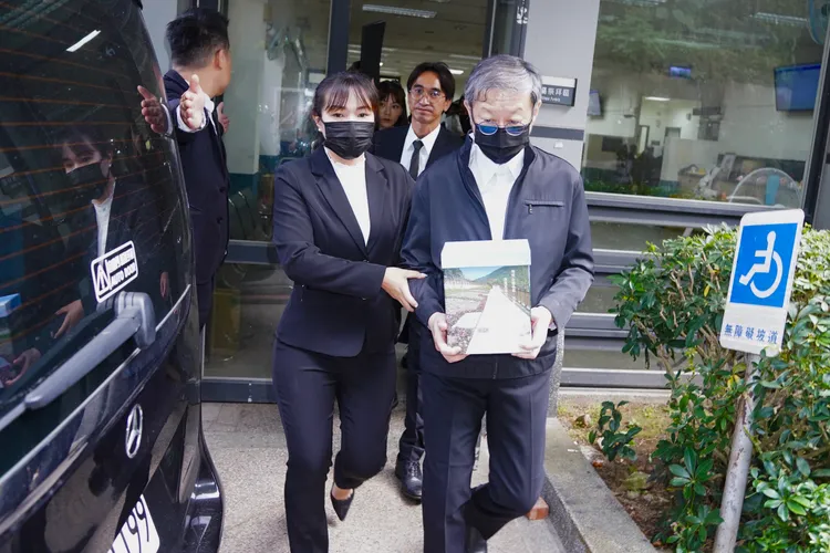 陳中維手捧瓊瑤骨灰出火葬場。彭欣偉攝影