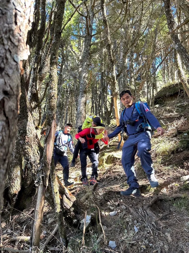 消防人員背負傷者至平坦處等候直升機救援。民眾提供