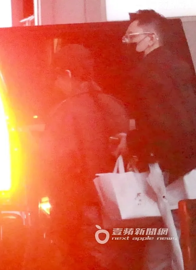 小鮮肉（右）戴著眼鏡，手提購物袋及雨傘陪伴蕭亞軒。特勤中心攝