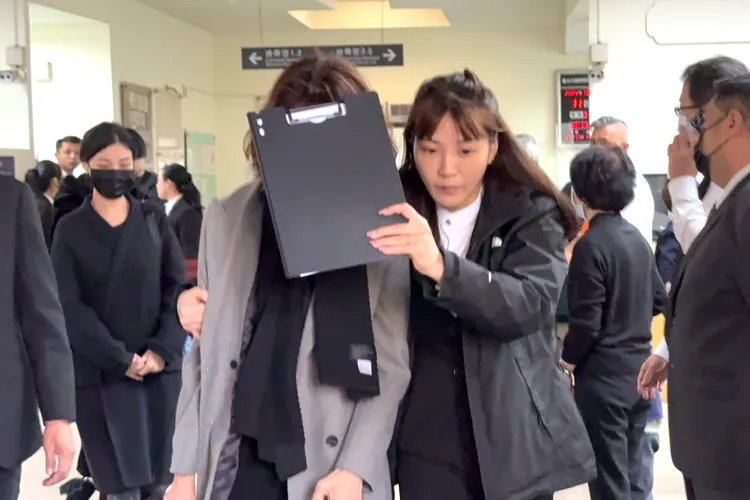 瓊瑤兒媳婦何琇瓊痛苦，禮儀公司人員幫忙遮臉。特勤中心攝