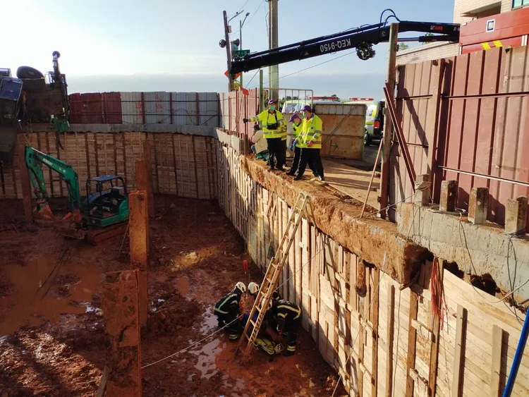 起重機司機掉落工地地下一樓，救護人員透過長背板將他吊掛救起脫困。翻攝畫面