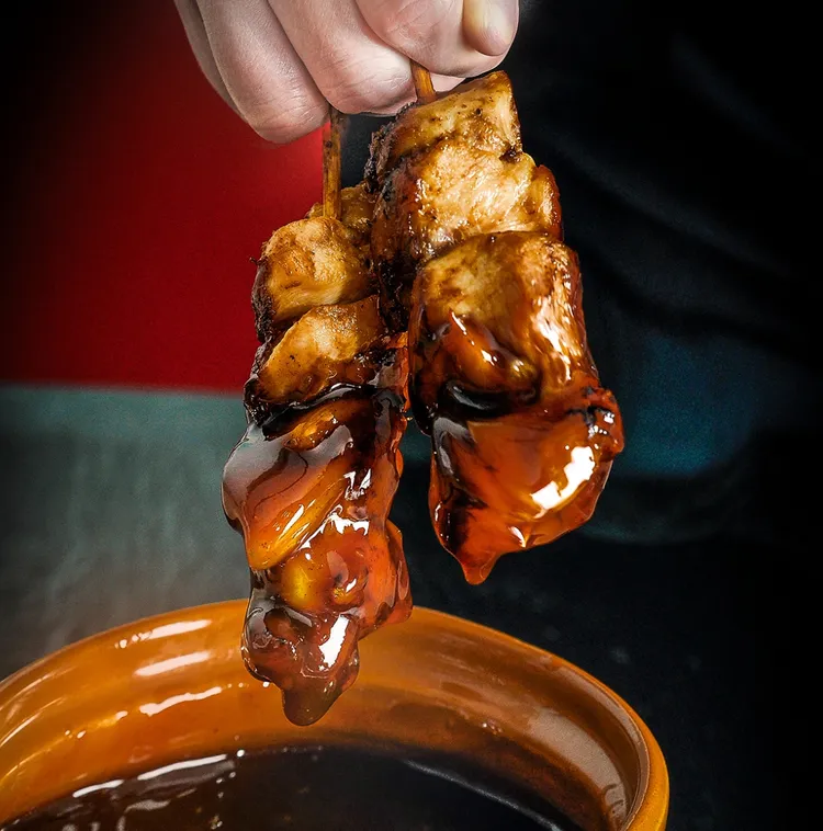 在炭火上炙烤的「日式燒鳥」反覆沾上特調濃厚醬汁，迷人的焦糖色澤搭配啤酒十分過癮。業者提供