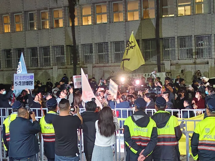 小草們集結在北檢外，與警戒的轄區警隔著鐵欄杆對峙。張欽攝