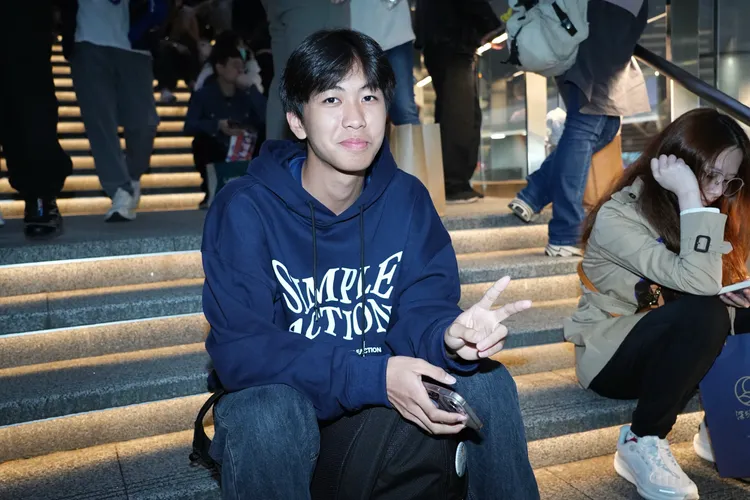 高三劉同學搶不到票，索性坐在場外樓梯盼能聽到場內歌聲。彭欣偉攝