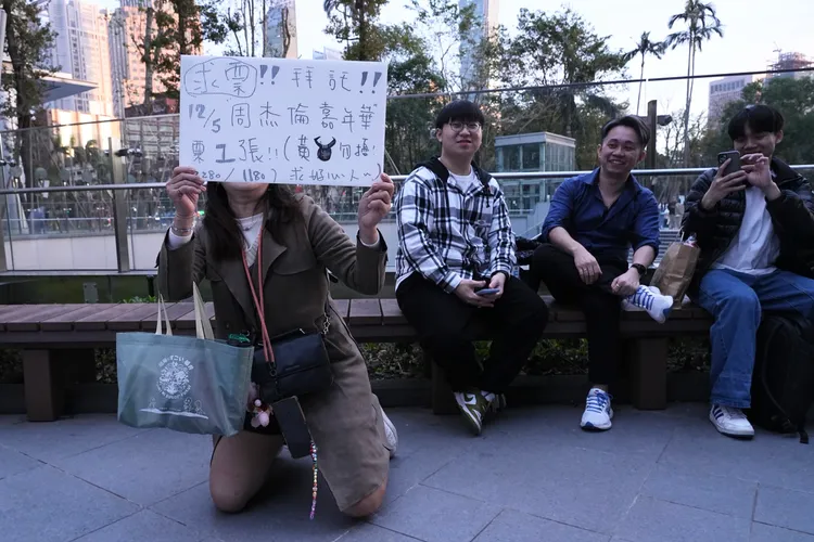 安安（左）舉牌下跪求票。彭欣偉攝