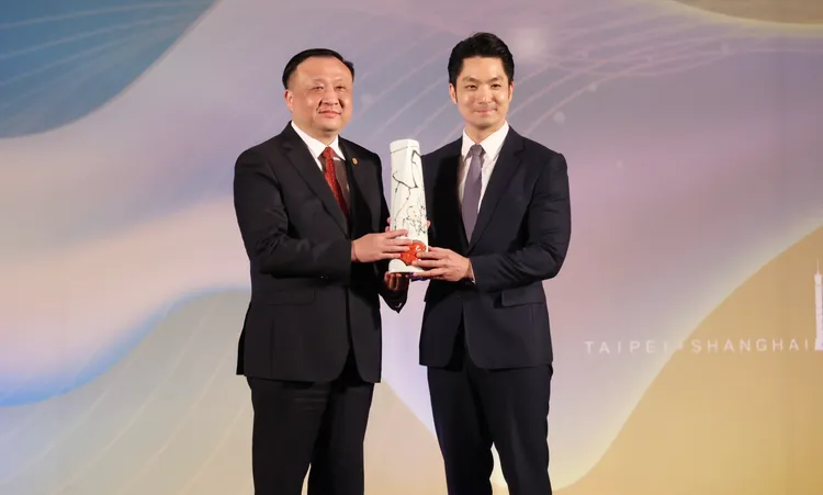 蔣萬安（右）和華源（左）互贈禮物並合影。莊宗達攝