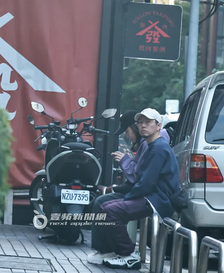 蛋堡與老婆坐在路邊欄杆上等店家營業。特勤中心攝