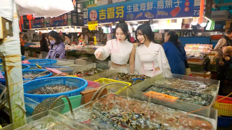 琳瑯滿目的蚵仔寮魚市場，讓螢螢(左)與一粒(右)大開眼界。市府提供