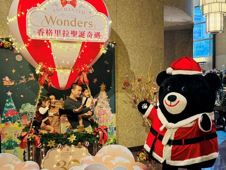 台北遠東香格里拉吉祥物台灣黑熊LaLa換上聖誕裝驚喜現身，在夢幻熱氣球前與大小朋友歡樂合影。業者提供
