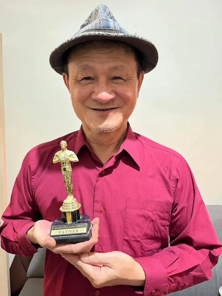 陳慕義手握的是女兒做給她的「奧斯卡最佳爸爸」獎座。翻攝自陳慕義臉書