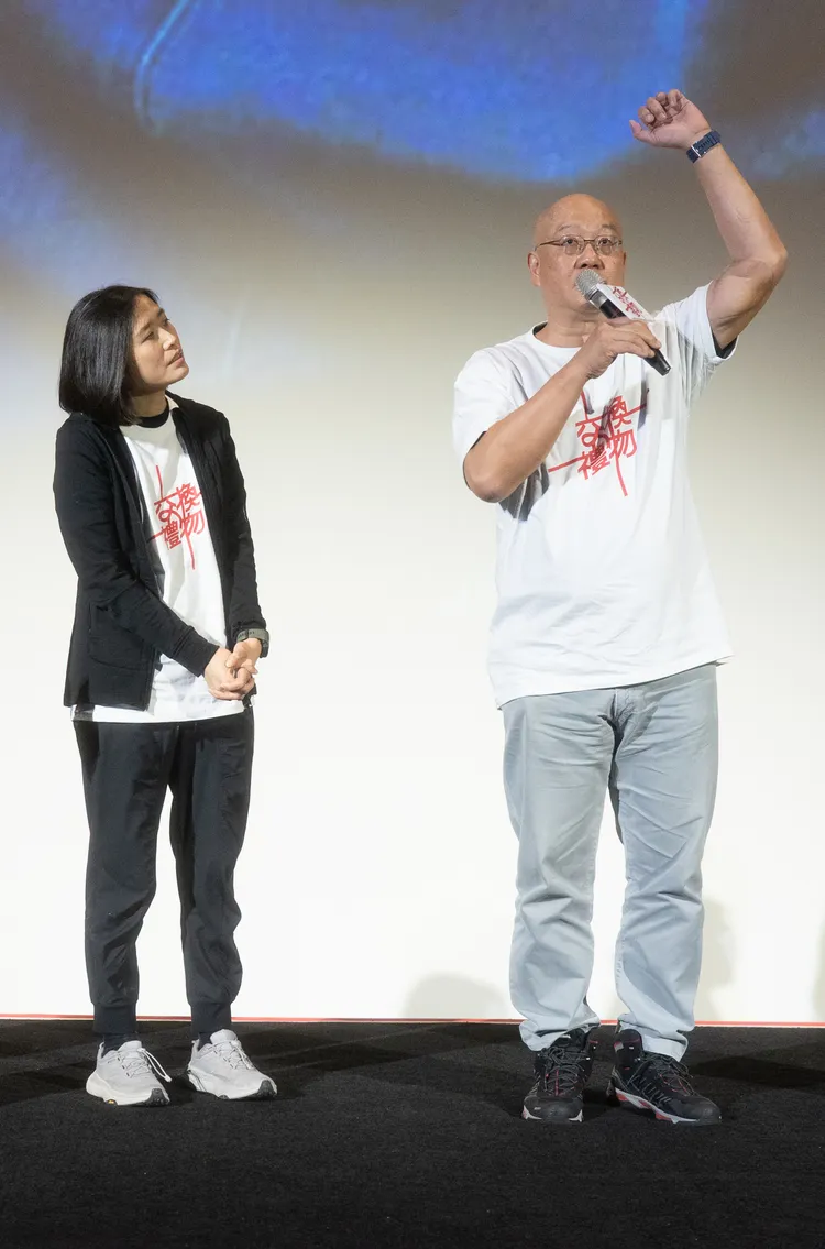 Sam哥（又）在首映會上秀出健康手臂，另一位康復者Olga也看得專注。台北双喜電影提供