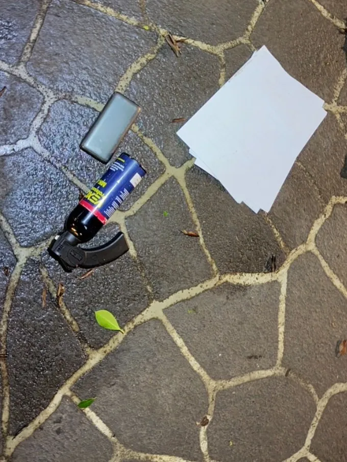 案發現場散落詐騙文件與辣椒水罐。翻攝畫面