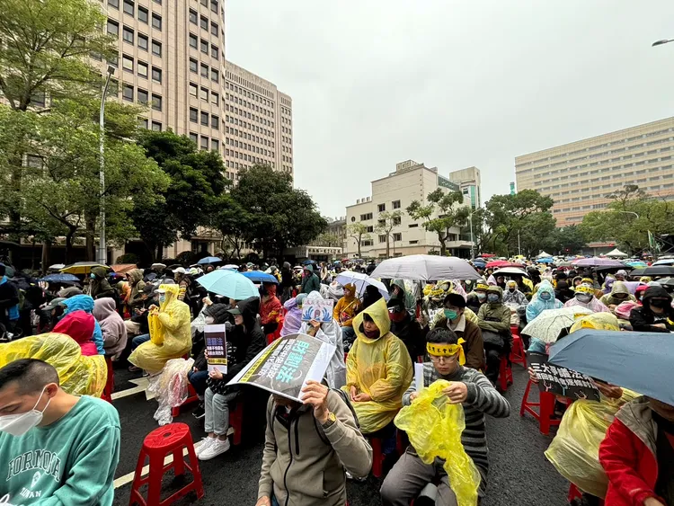 青鳥們拿起物品遮雨。江孟謙攝