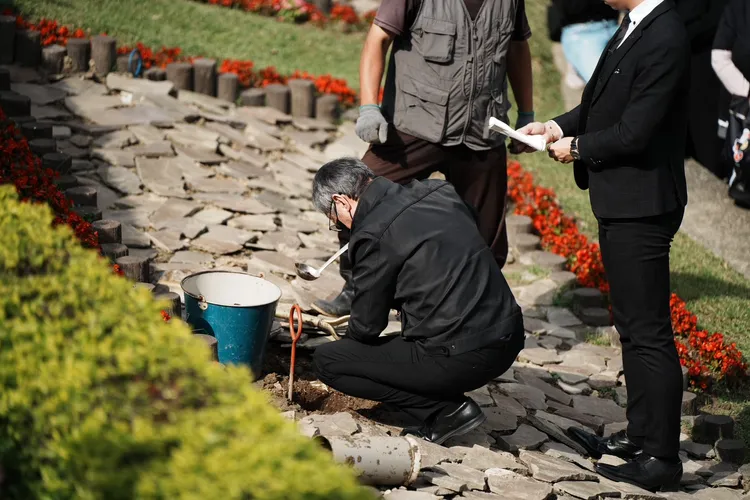 陳中維遵循墓園人員指示，將母親骨灰下葬。特勤中心攝影