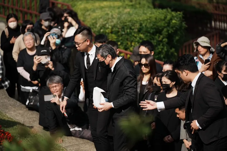 瓊瑤兒子陳中維手捧瓊瑤骨灰，遵循墓園人員指示，神情哀妻。特勤中心攝