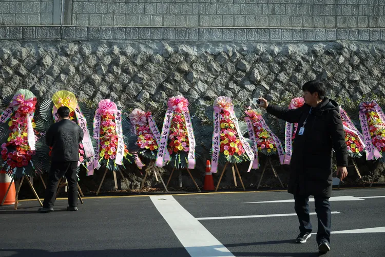 南韓總統辦公室大樓外，擺滿支持尹錫悅民眾所送的花圈。路透社