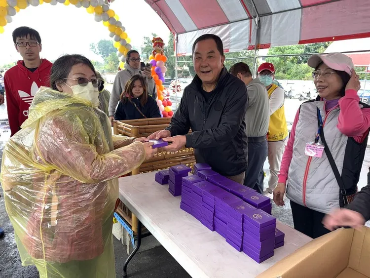 竹山鎮紫南宮元旦發送蛇年錢母，天寒降雨，許多民眾穿著雨衣排隊領錢母。中央社