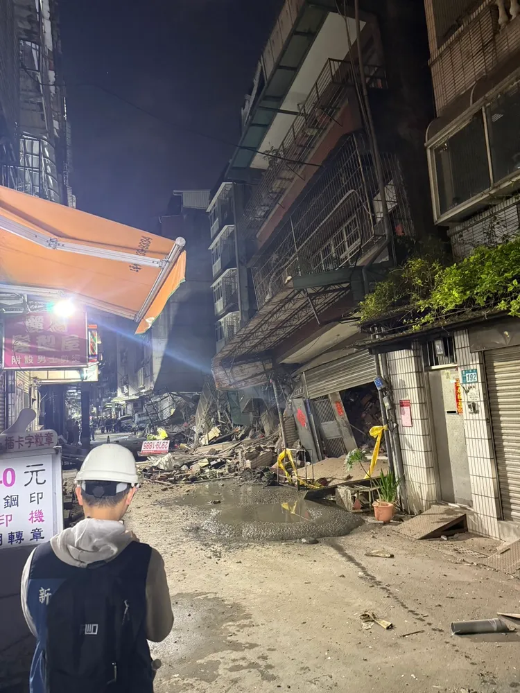 昨晚倒塌的建案已圍起封鎖線，市府也出動人員到場戒備。翻攝畫面