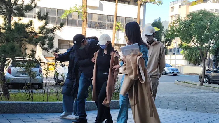 麥當勞17歲女工讀生的母親（白帽）今天在欽有吉律師陪同下抵達士檢。張欽攝