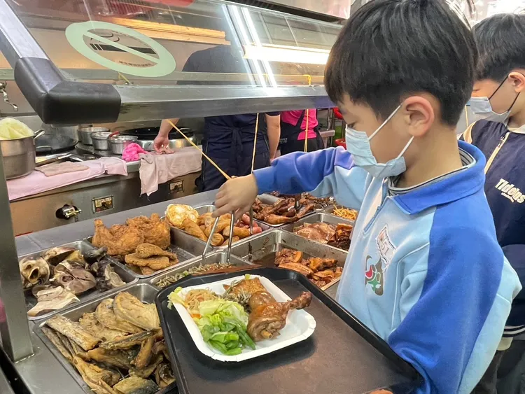 學童到自助餐店兌換午餐。教育局提供