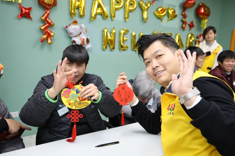 昇恆昌免稅商店總經理江建廷（右）和「安康啟智教養院」院生一起手作新年發財樹掛飾，活絡中心春節氛圍。昇恆昌免稅商店提供