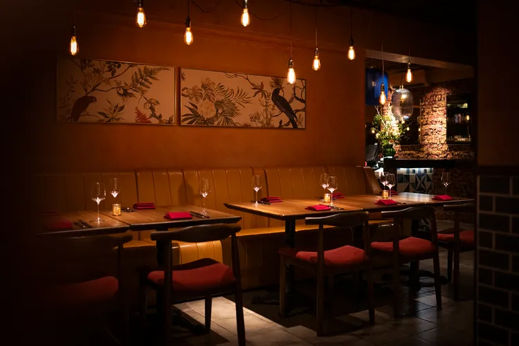 內部採用自然材質與溫暖色調，土黃色沙發、磚紅椅面與紅泥刷色牆面。業者提供